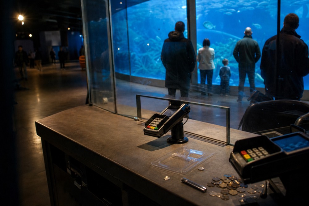 Aquarium ticket desk in a shopping mall basement, no text, no logos, no people.