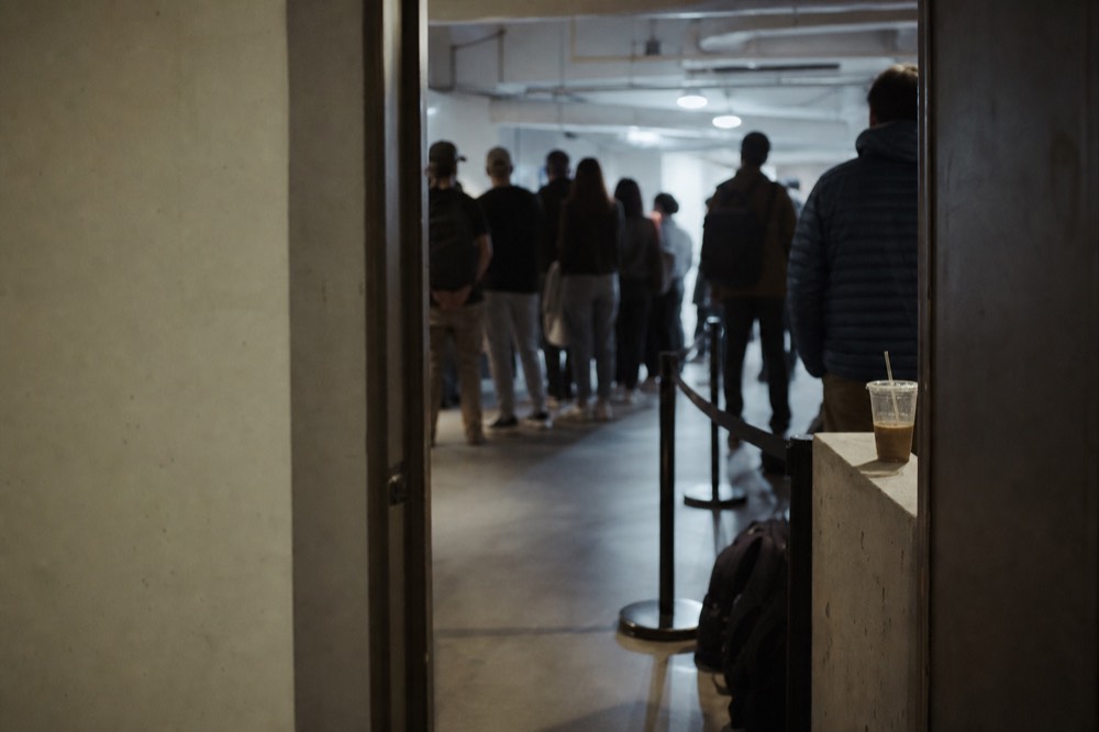 Visitors waiting at an aquarium entrance corridor in a mall basement, no text, no logos, no people.
