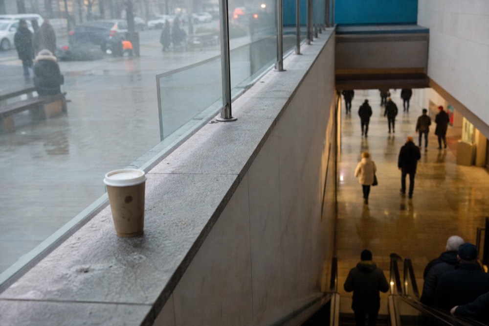 An escalator descending into a bright shopping mall basement towards an aquarium entrance, no text, no logos, no people